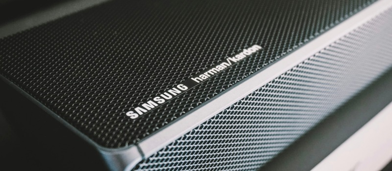 Detaljerad bild av gallret och logotypen på en Samsung-soundbar